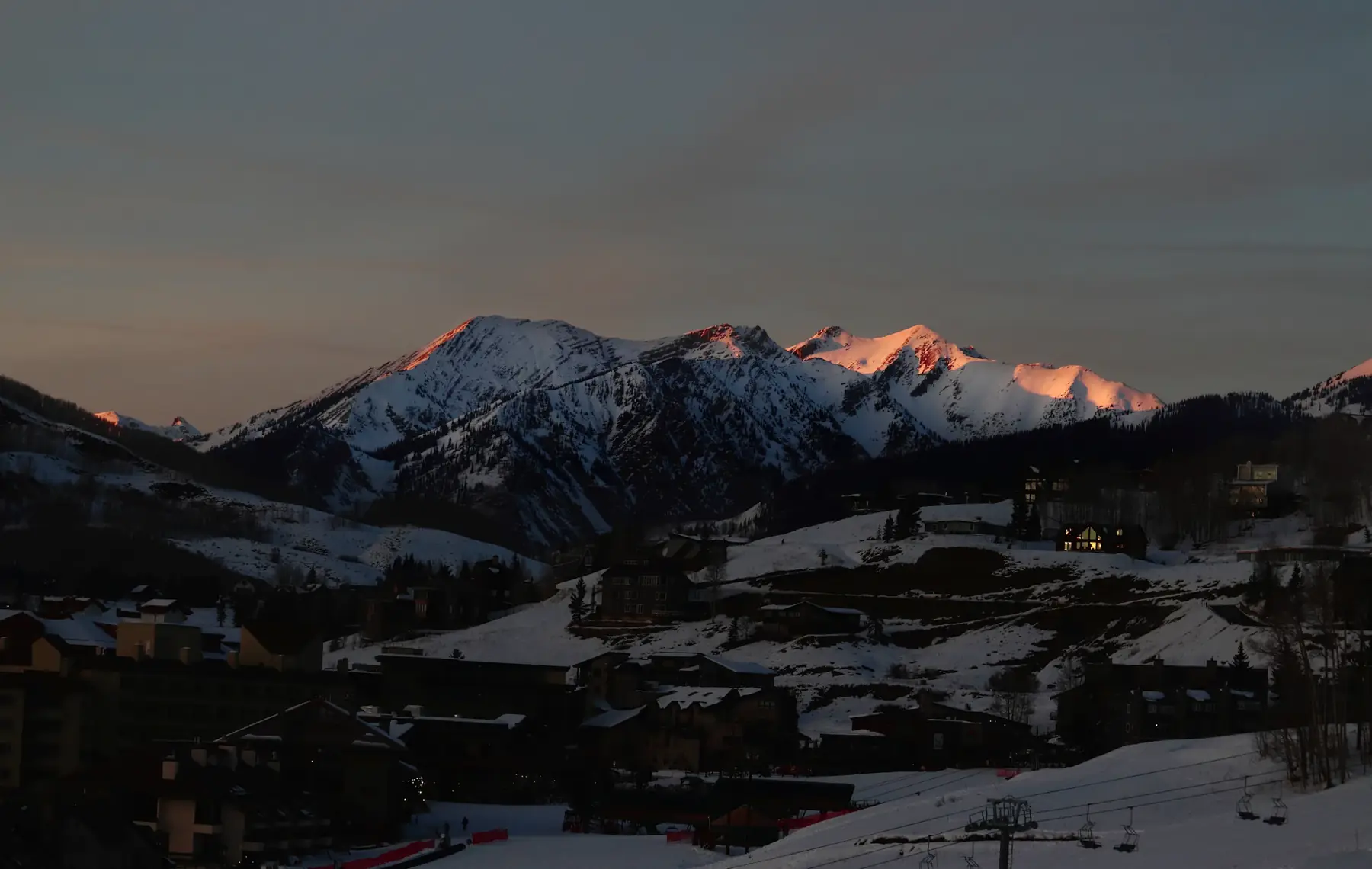 Evening view of the town of Crested Butte in the valley below snow-covered peaks